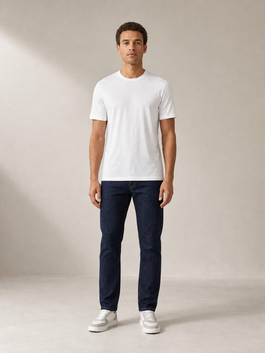 UOMO Fine White Tee front view on a male model in dark indigo jeans and grey-white sneakers