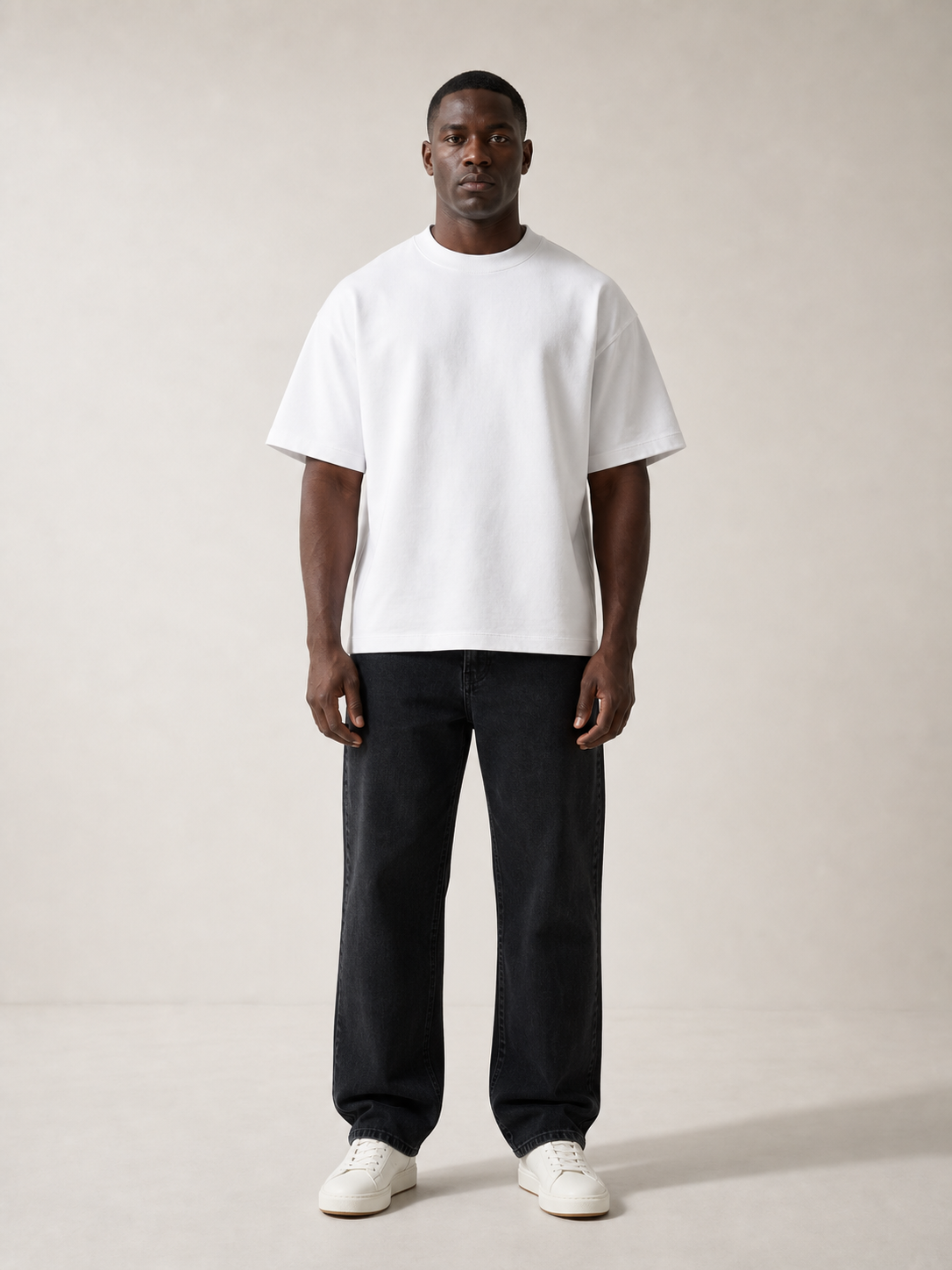 UOMO Heavyweight White Tee front view on a male model in washed black jeans and off-white sneakers